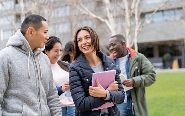 Group of diverse international students smiling and chatting outdoors on a UK university campus