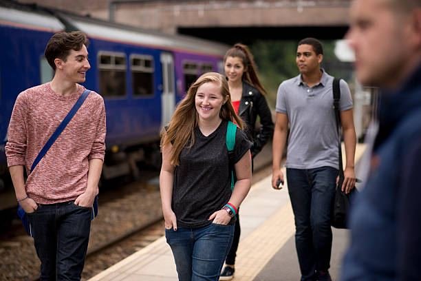 UK university students walking along a train platform, heading to or from campus